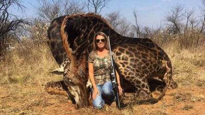 Tess Thompson Talley posando junto a su presa, una jirafa negra, un animal en peligro de extinción. Foto redes.