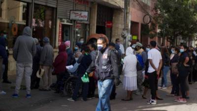 Decenas de personas hacen fila en un banco en Tegucigalpa el 8 de diciembre de 2020. EFE