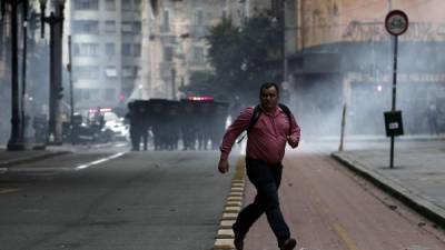 La policía antomotines trató de dispersar a los manifestantes con gases lacrimógenos en Sao Paulo.