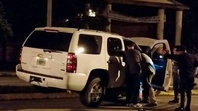 Elementos de la DNIC cuando inspeccionaban la camioneta ayer en la madrugada en busca de evidencias que los conduzcan a los homicidas.