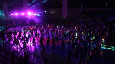 Los asistentes practicando zumba en el gimnasio.