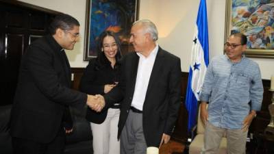 El sacerdote Carlos Rubio estrecha la mano del titular del CN, Mauricio Oliva. Observan Gabriela Castellanos y Alberto Solórzano.