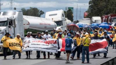 Workers of Costa Rican oil refinery Recope demonstrate outside a refinery in Cartago, Costa Rica, on September 19, 2018 during an indefinite strike called by the country's unions against a tax reform.The unions of the Costa Rican public sector began an indefinite strike on September 10, in opposition to a tax reform project which would mean an increase of taxes to face the bulky fiscal deficit. Due to the strike, gasoline is scarce in many gas stations across the country. / AFP PHOTO / Ezequiel BECERRA