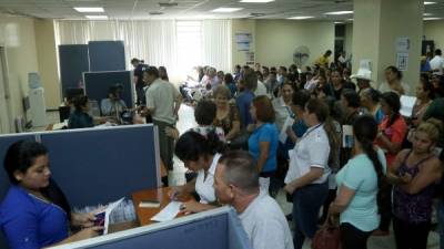 Usuarios esperan la entrega de su pasaporte en la oficina regional de San Pedro Sula. Foto: Melvin Cubas.