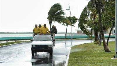 Un grupo de trabajadores circula por una avenida de la ciudad de Chetumal, del estado mexicano de Quintana Roo, durante el paso de la tormenta Earl. EFE