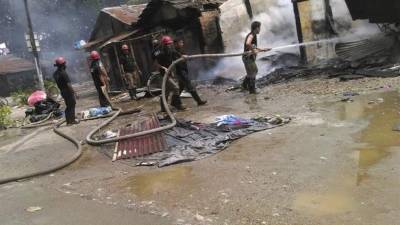 Varios bomberos tratan de controlar el incendio en un mercado tras el ataque con una granada y el tiroteo perpetrado en Kokrajhar, distrito del estado de Assam, India, hoy 5 de agosto de 2016. EFE