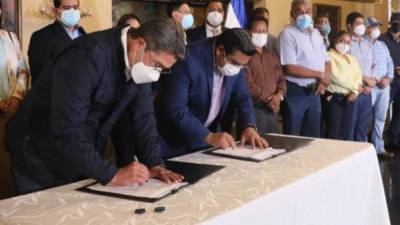 El presidente de Honduras, Juan Orlando Hernández, firma el acta del nuevo salario mínimo para el 2021.