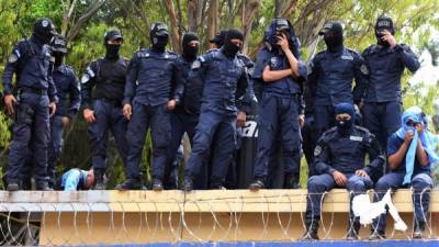 Members of the Honduran National Police Special Forces hold a sit-down strike against work harassment and abuse of authority, following their request to stop repression against the Honduran people, in Tegucigalpa on June 19, 2019. - For the past two months, the Honduran police has been clashing with teachers, doctors and students who have been staging protests against the government of Honduran President Juan Orlando Hernandez for measures they say will privatize health and education services. (Photo by ORLANDO SIERRA / AFP)