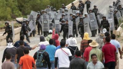 Maestros se enfrentan a policías estatales en Chiapas donde bloquearon carreteras e incendiaron material electoral.