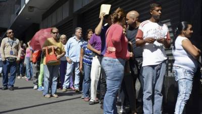 Caraqueños hacen fila frente a un supermercado en la capital venezolana.