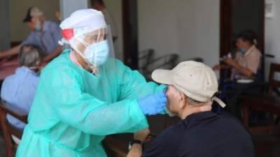 Un adulto mayor es atendido por personal médico.