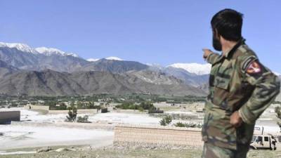 Un militares afgano apunta hacia la zona montañosa sobre la que EE.UU. lanzó la mayor bomba no-nuclear, la llamada 'Madre de todas las bombas', para destruir un complejo de túneles del autoproclamado Estado Islámico (EI), en la provincia de Nangarhar (Afganistán). EFE