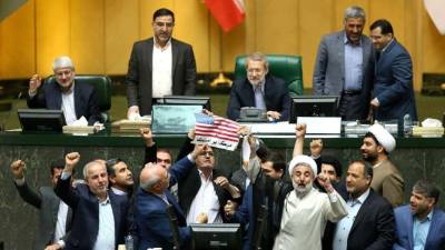 Un grupo de diputados iraníes queman una bandera de EE.UU. en protesta por la decisión del presidente estadounidense, Donald Trump, de retirarse del pacto nuclear. EFE