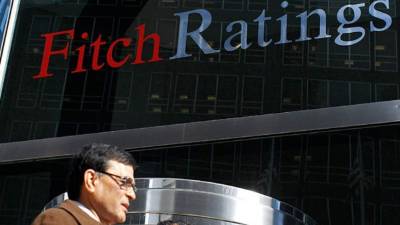 Un hombre camina frente a una oficina de Fitch Ratings en Estados Unidos.