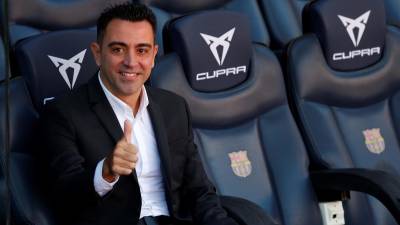 GRAFCAT9374. BARCELONA, 08/11/2021.- El nuevo entrenador del FC Barcelona, Xavi Hernández, posa en el banquillo del Camp Nou tras finalizar el acto de presentación como entrenador blaugrana.