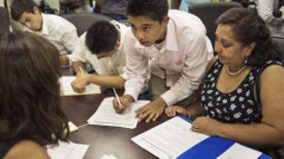 Bolivian Diego Mariaca(C), his mother Ingrid Vaca(R) and brother Gustavo Mariaca(L) fill out paperwork under the 'Dream Act' August 15, 2012 at the National Immigration Forum in Washington, DC. In June US President Barack Obama announced that hundreds of thousands of undocumented young people known as 'Dreamers' could apply for deferred action and work permits in the wake of the historic DHS decision that will protect them from deportation. AFP PHOTO/Paul J. Richards