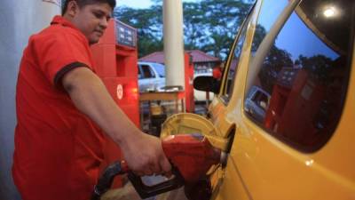 Empleado echa gasolina a una unidad.