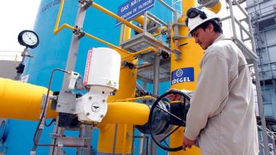 Un trabajador abre una válvula en una planta de gas natural licuado.