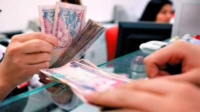 Un usuario paga los intereses en su tarjeta de crédito en la ventanilla de un banco.