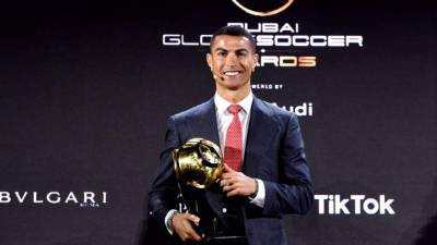 Cristiano Ronaldo posando con su premio al Mejor Jugador del Siglo XXI en los Globe Soccer Awards.