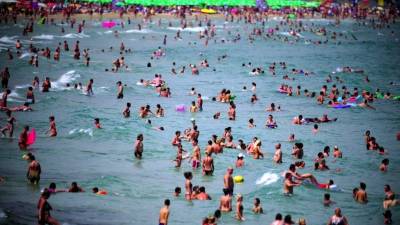 Cientos de personas se refrescan en las aguas del Mar Negro en una playa cerca de Nesebar, a unos 400 kilómetros de Sofia, Bulgaria. EFE/Archivo