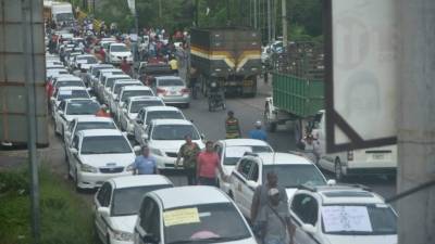 Julia Wilson, piloto certificada, conduce una unidad de los taxis rosas que llevan por nombre 'Taxi Sheula', este jueves, en San Pedro Sula (Honduras). EFE/José Valle