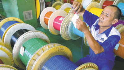 Un empleado se prepara para rotular cables de fibra óptica en Indonesia.