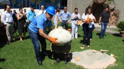 El alcalde Calidonio junto a niños del museo al enterrar el huevo simbólico de dinosaurio.