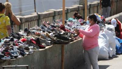 Fotografía de una mujer que vende zapatos usados en una calle de Tegucigalpa.