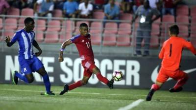 El delantero Eduardo Guerrero al momento de marcar su segundo gol de la noche con Panamá ante el portero de Honduras, Carlos Banegas.