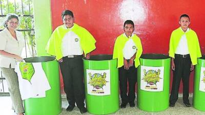 Carmen Montes, subdirectora de la jornada vespertina y alumnos del centro básico Presentación Centeno, al momento de recibir los recipientes.