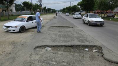 En una de las trochas del bulevar del este se han formado inmensos agujeros que agudizan el tráfico.