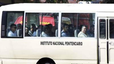 Los exalcaldes Óscar Kilgore y Arnaldo Urbina Soto, entre otros reos, en el último bus que trasladó ayer a parte de los 206 internos al penal de El Progreso.