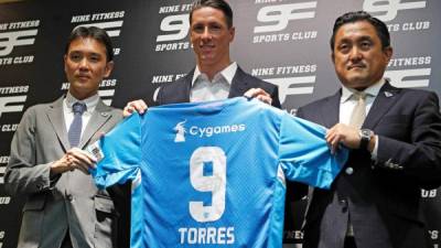 El director deportivo del Sagan Tosu (i), el delantero Fernando Torres (c), y el presidente del club japones, Minoru Takehara (d), durante el acto de presentación del delantero. FOTO EFE.