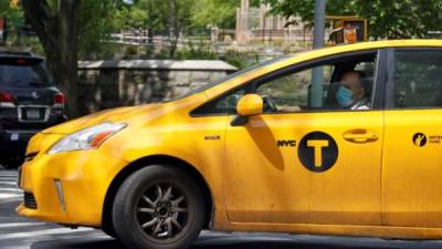 Un taxista de la ciudad de Nueva York es visto usando una máscara mientras conduce por Central Park West, en Nueva York. EFE