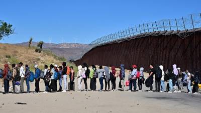 Migrantes hacen fila para entregarse a la Patrulla Fronteriza y solicitar asilo en EEUU.
