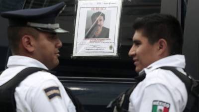 Policías mexicanos ante uno de los miles de carteles con la efigie de 'El Chapo' repartidos por el país.