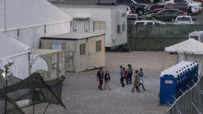 Immigrants are pictured behind the fences of a temporary facility set up to hold them at the El Paso Border Patrol Station, on June 21, 2019. (Photo by Paul Ratje / AFP)