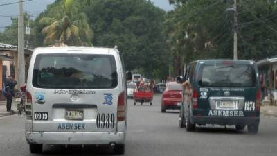 Dos microbuses o rapiditos de la ruta 2 captados ayer en el barrio Cabañas de San Pedro Sula.