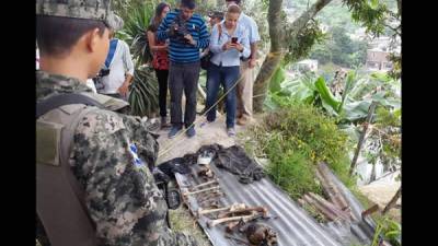 Un militar hondureño y varios periodistas en el hallazgo registrado hoy en el occidente de Honduras.