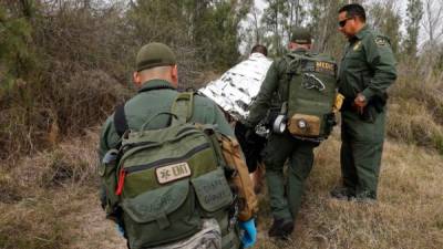 Agentes de la Patrulla Fronteriza custodian a migrantes detenidos.