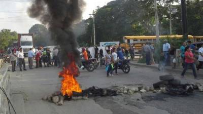 Miembros de la Resistencia mantienen bloqueado el puente del sector El Carmen en el segundo anillo de San Pedro Sula.