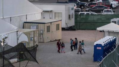 (FILES) In this file photo taken on June 21, 2019 Immigrants are pictured behind the fences of a temporary facility set up to hold them at the El Paso Border Patrol Station. - The Customs and Border Protection (CBP) agencys acting commissioner, John Sanders, is expected to step down, a development that comes as the agency faces continuing public fury over the treatment of detained migrant children. The news of the resignation came shortly after agency officials disclosed that more than 100 children have been returned to a troubled Border Patrol station in Clint, Texas, a location where a group of lawyers who visited recently said hundreds of minor detainees had been housed for weeks without access to showers, clean clothing, or sufficient food. (Photo by Paul Ratje / AFP)