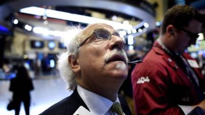 Corredores observan los resultados de las cotizaciones de la Bolsa.