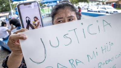 La migrante hondureña Nancy muestra una foto de su sobrina Elsy Marian Rodas Cortez, quien murió durante el incendio del pasado 20 de junio en una cárcel de mujeres en Tamara, Honduras, durante una protesta a favor de la inmigración en Miami, Florida, EE.UU.