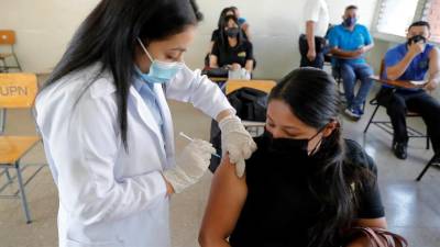 Trabajadora de la Salud vacuna a una mujer contra el coronavirus en Tegucigalpa.