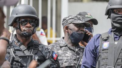 En esta foto de archivo, Leon Charles, jefe de la Policía Nacional de Haití da órdenes por un walkie-talkie mientras la multitud rodea la comisaría de Petionville donde se acusa a hombres armados de estar involucrados en el asesinato del presidente Jovenel Moïse.
