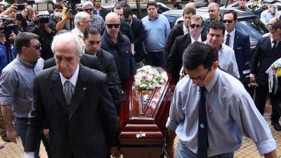 El padre del fiscal antidrogas paraguayo Marcelo Pecci, Francisco Pecci, lleva su ataúd con otros familiares y amigos, antes de una misa en la iglesia San José antes de su funeral, en Asunción.
