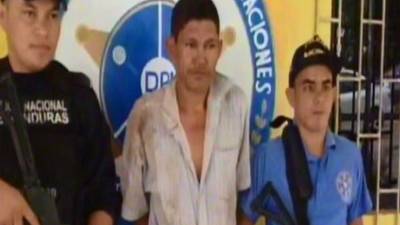 El detenido es custodiado por dos agentes policiales.