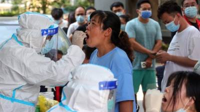 Una mujer recibe una prueba de ácido nucleico para el coronavirus. Foto AFP